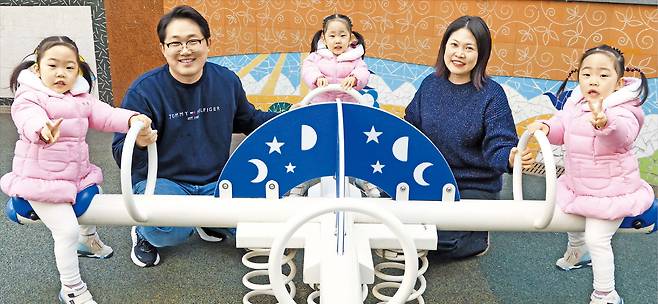 14일 서울 송파구 자택 앞 놀이터에서 아빠 민덕기(왼쪽)씨와 엄마 김한솔씨가 세쌍둥이 딸 세희(왼쪽부터), 세은, 세아를 시소에 태우고 있는 모습. 김씨는 “이른둥이로 태어나 신생아중환자실 신세를 졌던 세 아이가 모두 퇴원했을 때 세상 그 누구보다 큰 부자가 된 것 같았다”고 했다./고운호 기자
