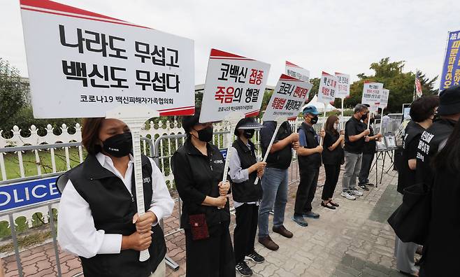 지난 2022년 9월 코로나19 백신 피해자 가족협의회 회원들이 서울 여의도 국회 앞에서 손팻말을 들고 있다. /뉴스1