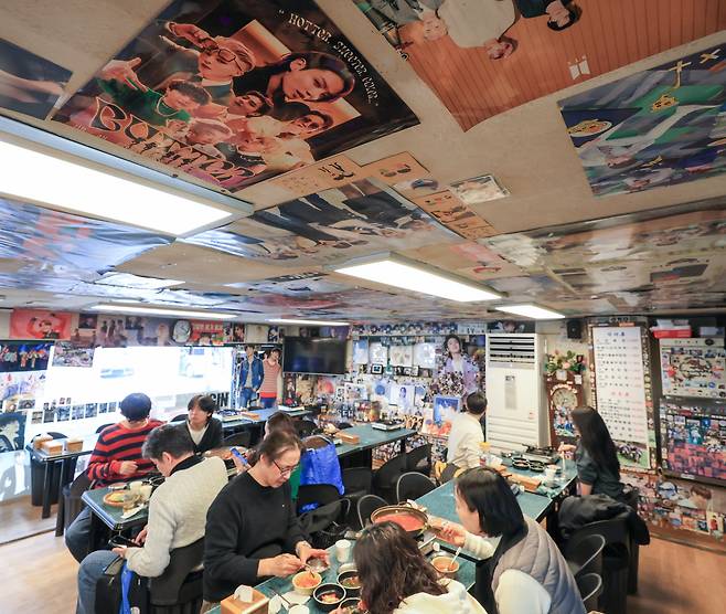 지난 15일 점심 시간 방문한 서울 강남구 유정식당 내부 벽면과 천장이 BTS 멤버들의 사진으로 뒤덮여 있다. BTS가 연습생 시절 자주 찾았다고 알려진 쌈밥집이다. 티슈 케이스와 수저통에까지 사진이 붙어 있다. 식당 주인은 “주말 외국인 손님의 80%가 아미”라며 “오겹살이 가장 인기가 많다”고 했다. /박성원 기자