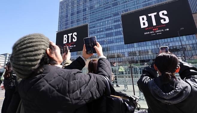 그룹 방탄소년단(BTS)의 서울 광화문광장 컴백 공연이 이틀 앞으로 다가온 19일 서울 종로구 광화문광장에서 외국인 팬들이 컴백 공연을 알리는 전광판 광고를 스마트폰으로 촬영하고 있다. /뉴스1