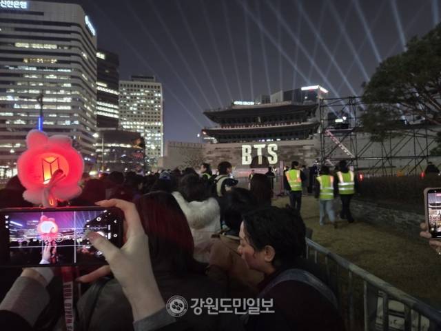 ▲ 방탄소년단의 ‘BTS 컴백 라이브: ARIRANG’ 서울 광화문 무대를 하루 앞둔 20일 서울 숭례문에서 미디어파사드 이벤트가 열렸다. 한 외국인 팬이 자신의 ‘아미밤(Army Bomb·응원봉)과 함께 기념사진을 찍고 있다. 김여진 기자