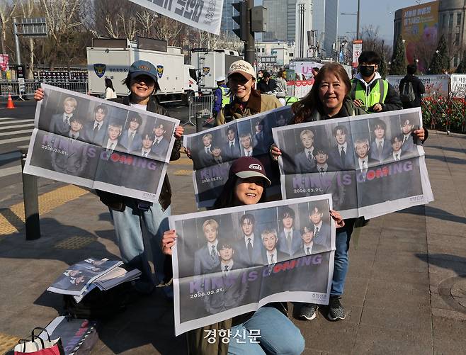 방탄소년단(BTS)의 컴백 공연을 보기 위해 한국은 찾은 외국인 팬들이 21일 서울광장에서 경향신문이 특별판으로 제작한 ‘BTS 굿즈’를 들고 포즈를 취하고 있다. 2026.3.21. 강윤중 기자