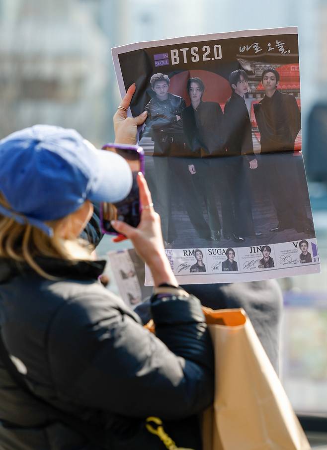 방탄소년단(BTS) 광화문 컴백 공연이 펼쳐지는 21일 서울 종로구 광화문 광장에서 한 외국인 아미(BTS 팬덤 명칭)가 세계일보 특별판 지면을 촬영하고 있다.