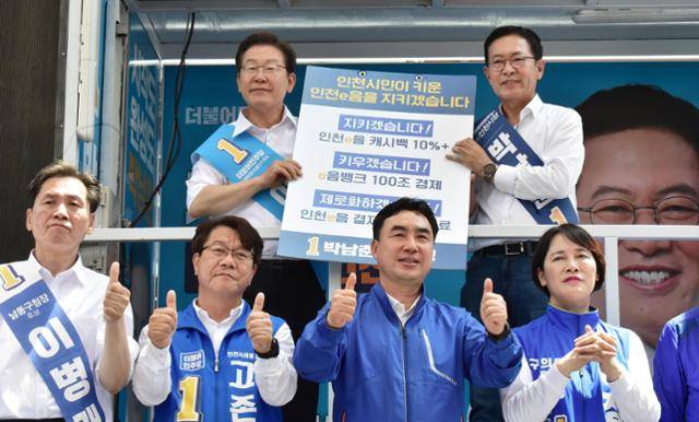 제8회 전국 동시지방선거(국회의원 보궐선거)가 하루 앞으로 다가온 2022년 5월 31일 인천 남동구 호구포로 모래내시장을 찾은 이재명 당시 더불어민주당 총괄선대위원장(계양을 국회의원후보), 박남춘 인천시장 후보가 인천발전 기자회견후 공약을 적은 피켓을 들고 있다. 한국일보 자료사진