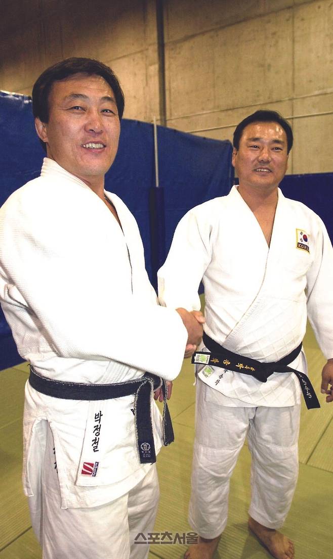 박종학 한국대표팀 유도감독(오른쪽)이 북한의 박정철 감독을 만나 악수를 하고 있다. 사진 | 시드니 사진공동취재단