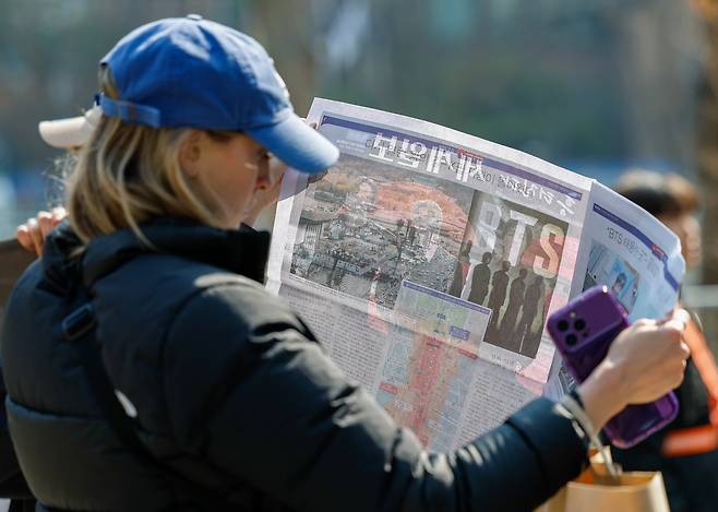 방탄소년단(BTS) 광화문 컴백 공연이 펼쳐지는 21일 서울 종로구 광화문 광장에서 한 외국인 아미(BTS 팬덤 명칭)가 세계일보 특별판 지면을 살펴보고 있다, 유희태 기자