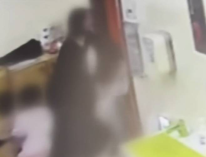 국회 어린이집 교사가 아동 양팔을 잡고 옆 교실로 내던지고 있다. (사진=JTBC 캡처)