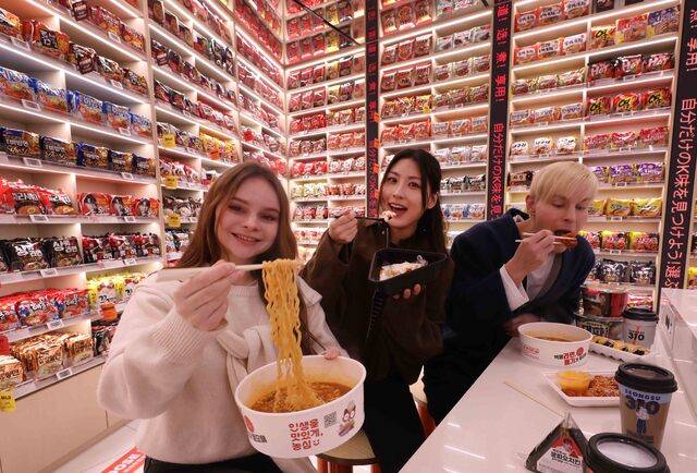 이마트24가 ‘체험형 편의점’ 전략을 앞세워 점포 경쟁력 강화에 속도를 내고 있다. 사진은 이마트24 ‘K-푸드랩 명동점’ 2층에서 모델들이 즉석라면을 직접 조리하고 테이블에 앉아 라면과 분식 등 다양한 K-메뉴를 즐기고 있다. ‘K-푸드랩 명동점’ 2층은 상시 재생되는 K-POP 음악과 압도적인 규모의 라면 아카이브 월이 더해지고, K푸드존까지 유기적으로 연결되며 고객이 마치 한국의 라면 문화를 한 공간에서 여행하듯 체험할 수 있도록 구성했다.(이마트24 제공)
