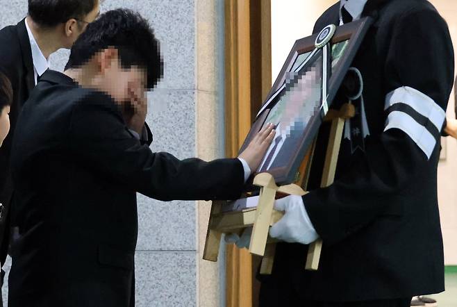 25일 대전 대덕구 안전공업 화재 참사 희생자의 발인식이 엄수된 가운데 참사로 아버지를 잃은 초등학생 아들이 고인의 얼굴을 쓰다듬고 있다. 연합뉴스