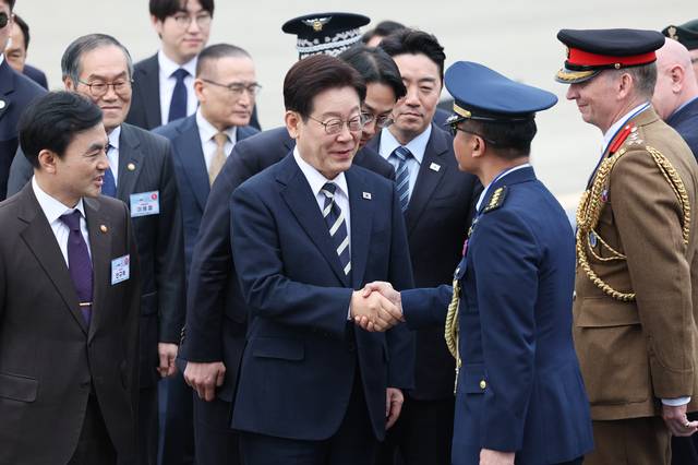 이재명 대통령이 25일 경남 사천 한국항공우주산업(KAI)에서 열린 KF21 양산 1호기 출고식에 입장하며 참석자들과 인사하고 있다. /청와대통신사진기자단 제공