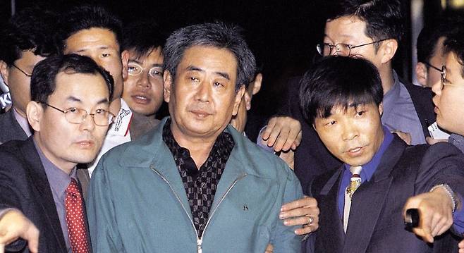 김근태 초대 민청련 의장을 고문한 이근안(가운데)씨가 1999년 11월 검찰에 송치되고 있다. 1988년부터 11년 가까이 도망 다니다 자수한 이씨는 7년의 실형을 살고 나온 뒤 목사로 변신했다. <한겨레> 자료사진