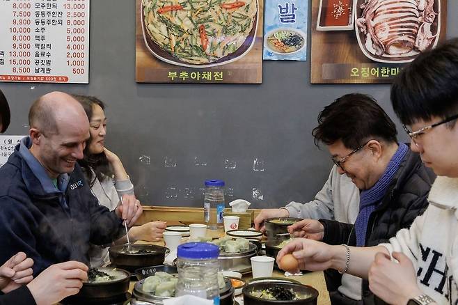 해럴드 로저스 쿠팡 한국 대표가 20일 염태영 더불어민주당 의원과 함께 새벽배송을 끝내고 국밥을 먹고 있다. 사진 쿠팡