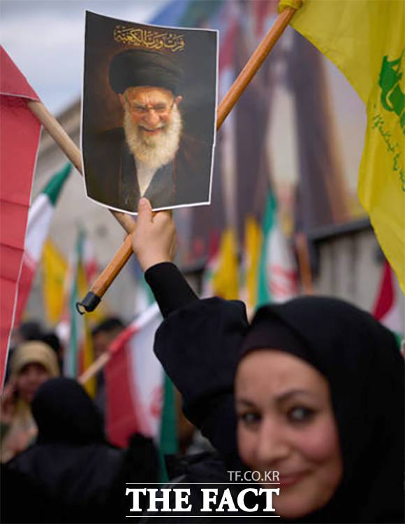 한 여성이 이슬람 공화국 연대 시위에 참가해 전 이란 최고 지도자 아야톨라 알리 하메네이의 초상화를 들고 있다.
