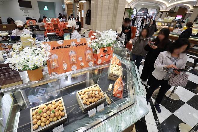 가수 지드래곤이 설립한 저스피스 재단과 80년 전통의 부창제과가 협업한 '데이지 밤(DAISY BOMB) 호두과자'가 정식 출시된 26일 서울 신세계 백화점 강남점 '스위트파크' 팝업스토어 부창제과에서 팬들이 제품을 구매하기 위해 줄을 서고 있다. /사진=뉴시스