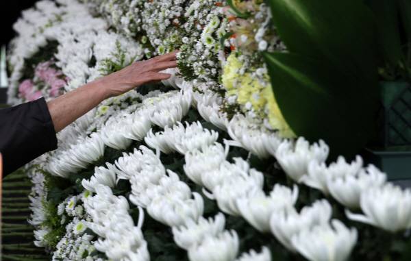 지나 22일 대전시청에 마련된 대전 안전공업 화재 희생자 합동분향소에서 한 유족이 아들 이름을 향해 손을 뻗고 있다. 연합뉴스