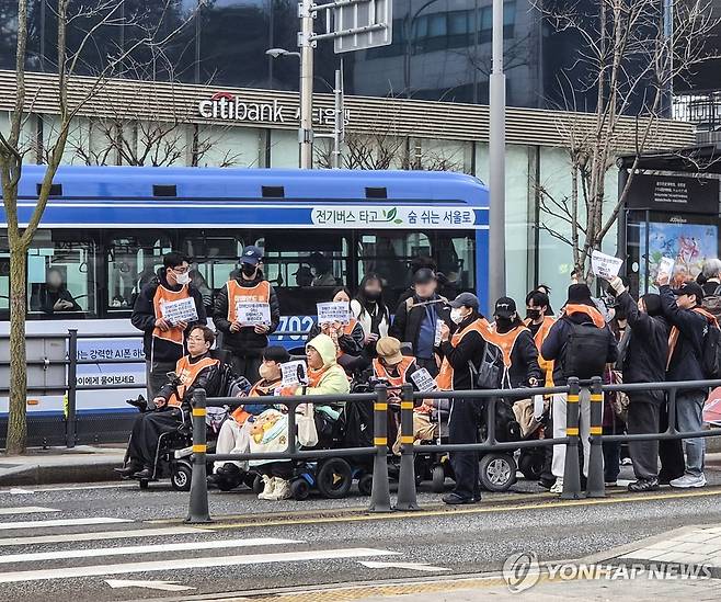 전장연, 광화문 일대서 '탑승 시위' (서울=연합뉴스) 이율립 기자 = 전국장애인차별철폐연대(전장연) 회원들이 27일 출근길 서울 종로구 광화문 버스 승강장에서 '탑승 시위'를 벌이고 있다. 2026.3.27 2yulrip@yna.co.kr