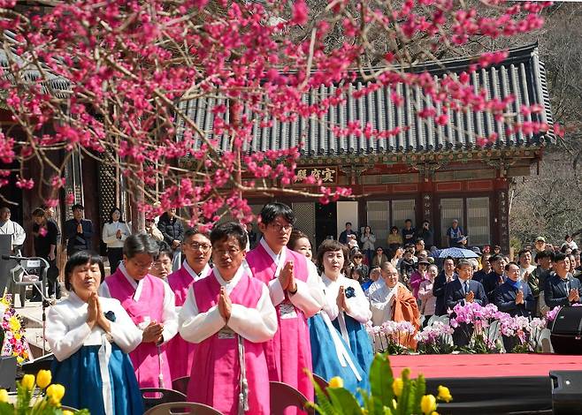 봄을 알리는 홍매화가 활짝 핀 지난 21일 전남 구례군 지리산 화엄사에서 열린 제6회 홍매화 들매화 프로사진 및 휴대폰사진 콘테스트 개막식에서 주지 우석스님 등 참석자들이 합장하고 있다. 연합뉴스