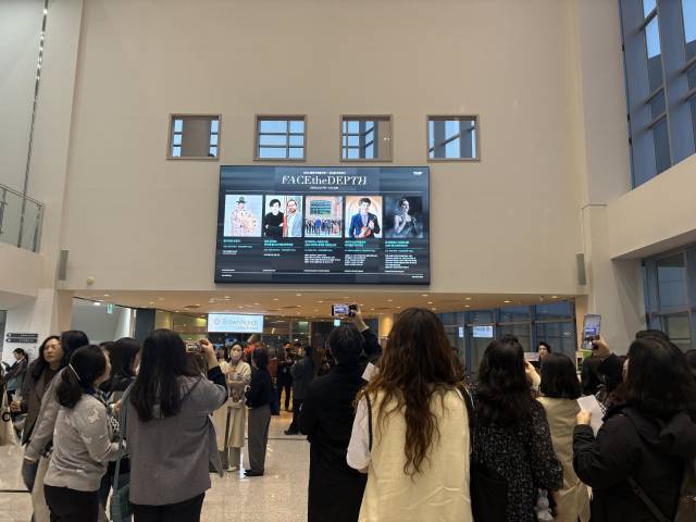 관람객들이 프로그램 소개 전광판을 찍고 있다.