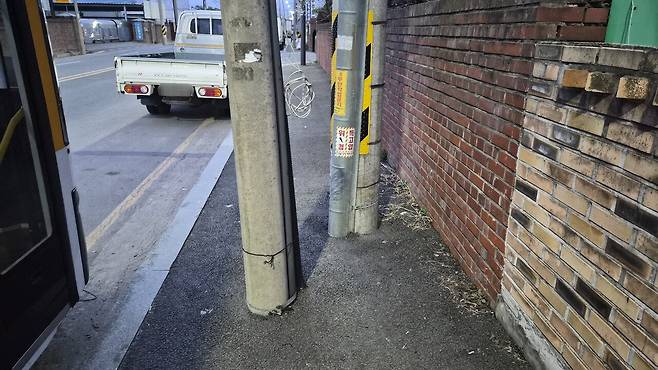 29일 광주 서구 유덕동의 한 보행로 중앙에 전봇대 두개가 서 있어 시민의 통행을 방해하고 있다. 김현수 기자