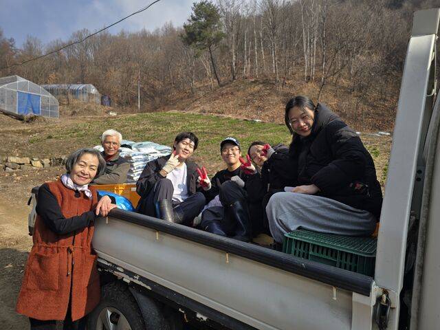 우프 활동 참여 청년들이 트럭 위에 자작나무 수액을 옮기며 서로에게 응원을 건네고 있다.