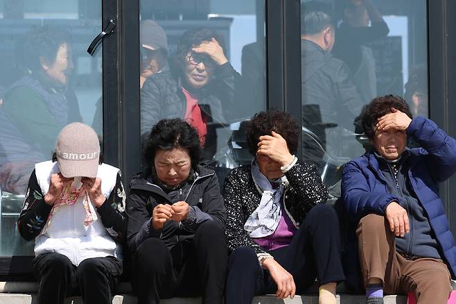 해녀들이 굿을 지켜보며 눈물 흘리고 있다.