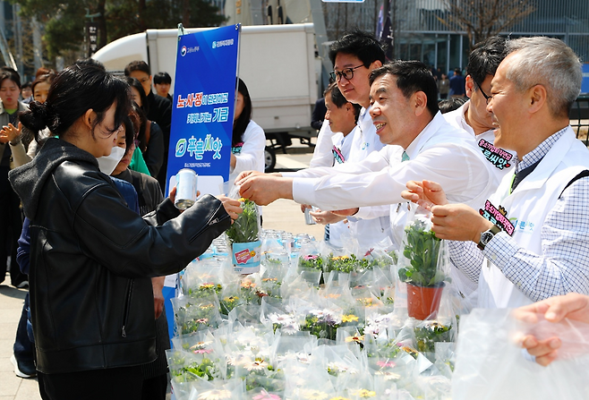 박종길 근로복지공단 이사장과 임직원들이 2일 서울 청계천 장통교 일대에서 시민들에게 미니 화분을 나누면서 '푸른씨앗' 확산을 위한 거리 캠페인을 진행하고 있다. /사진=근로복지공단
