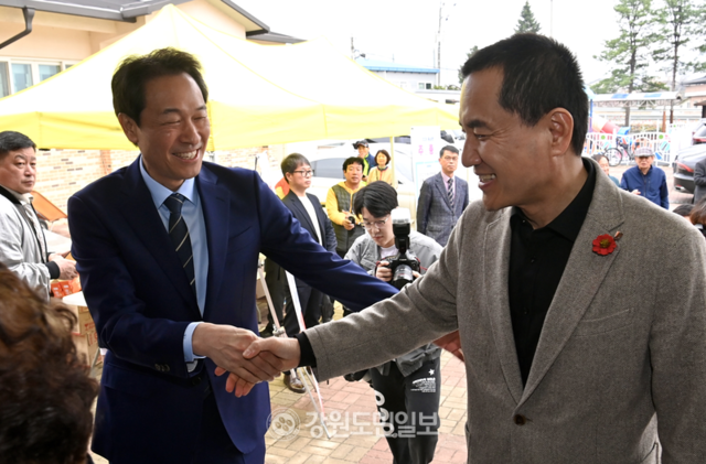 ▲ 김진태 강원도지사와 우상호 더불어민주당 강원도지사 예비후보가 4일 춘천 동내초에서 열린 ‘제19회 동내면 면민의 날 화합 큰잔치’ 행사장 입구에서 악수를 나누고 있다. 방도겸 기자