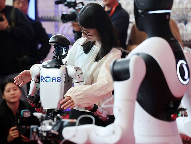 (서울=뉴스1) 박지혜 기자 = 4일 서울 강남구 코엑스에서 열린 ‘2026 스마트공장·자동화산업전(AW 2026)’에서 참관객이 중국 휴머노이드 로봇 유니트리의 G1과 인사를 나누고 있다. 2026.3.4/뉴스1 Copyright (C) 뉴스1. All rights reserved. 무단 전재 및 재배포, AI학습 이용 금지. /사진=(서울=뉴스1) 박지혜 기자