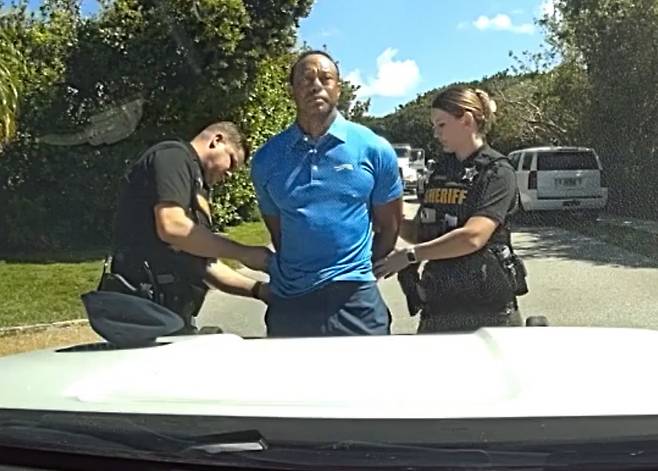 In this image from police body camera video released by the Martin County, Fla., Sheriff's Office, golfer Tiger Woods is taken into custody by sheriff's deputies following a car crash in Jupiter Island, Fla., Friday, March 27, 2026. (Martin County Sheriff's Office via AP) AP PROVIDES ACCESS TO THIS PUBLICLY DISTRIBUTED HANDOUT PHOTO PROVIDED BY THE MARTIN COUNTY SHERIFF'S OFFICE; MANDATORY CREDIT. IMAGE TAKEN FROM POLICE BODY CAMERA VIDEO
<저작권자(c) 연합뉴스, 무단 전재-재배포, AI 학습 및 활용 금지>