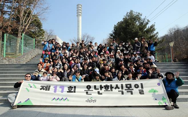 서울환경연합 회원과 시민들이 지난달 21일 서울 마포구 한강공원에서 열린 ‘제17회 온난화 식목일’ 행사에 참여해 단체 사진을 촬영하고 있다. 서울환경연합 제공