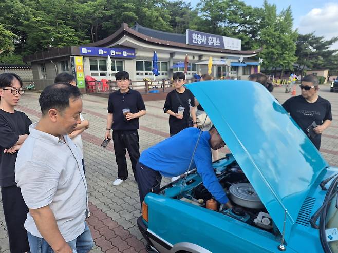 아산 현충사에서 네이버 카페 ‘포니타는사람들’ 회원들이 모여 엔진룸을 살펴보는 가운데 지나가던 시민들이 발걸음을 멈추고 구경하는 모습. 김상국(49) 씨 제공