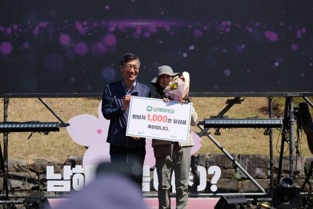 남해바래길 완보자 1000호에 이름을 올린 박주란 씨가 기념사진을 찍고 있다. 남해군 제공