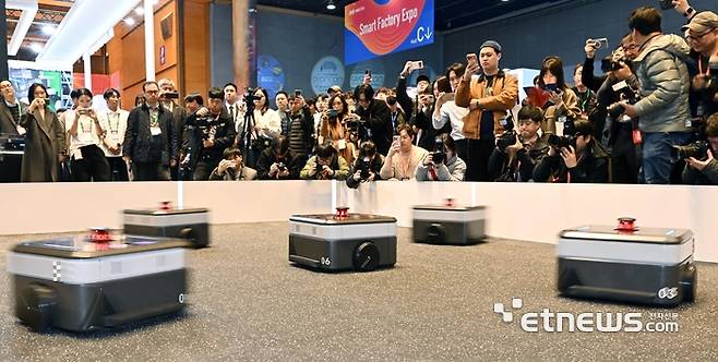 아시아 대표 제조 혁신 전시회 '2026 스마트공장·자동화 산업전(AW 2026)'이 4일 서울 강남구 코엑스에서 열렸다. 참관객이 현대무벡스의 자율주행기반 물류 자동화 로봇의 군집 운행 시연을 살펴보고 있다. 이동근기자 foto@etnews.com