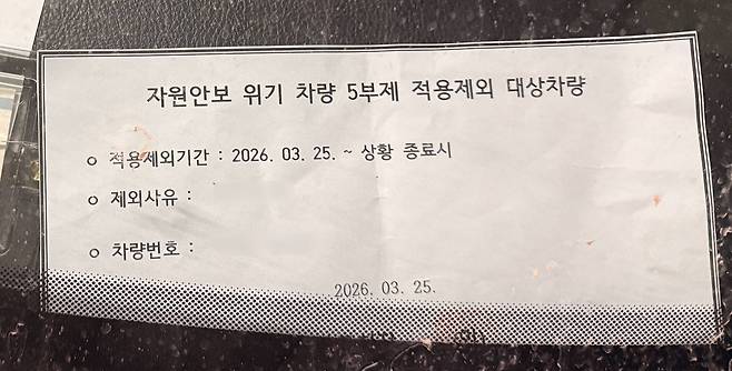 8일 오전 서울 동작구청 주차장에 주차된 차에 차 5부제 적용 제외 이유가 적힌 비표가 놓여 있다. /이호준 기자