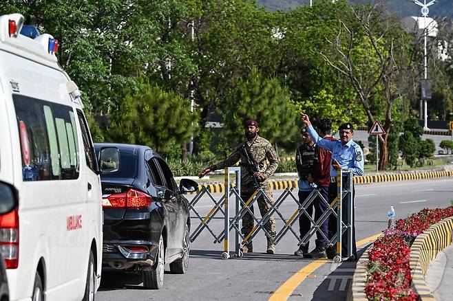 9일(현지시간) 미국과 이란의 고위급 회담이 열릴 예정인 파키스탄 이슬라마바드 도심 '레드존'의 한 도로에서 경찰이 차량에게 돌아가라고 지시하고 있다. 2026.04.09 ⓒ AFP=뉴스1