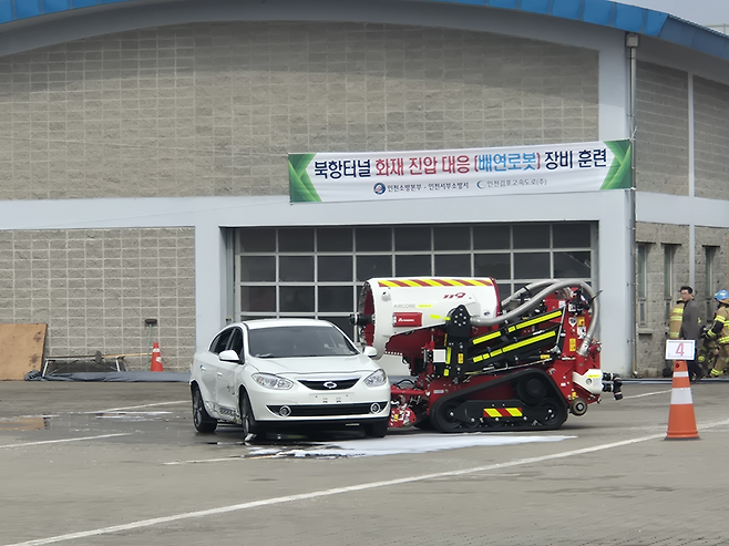 ▲ 10일 오후 인천김포고속도로 남청라영업소에서 열린 지하 화재 대응 장비 시연에서 궤도형 배연로봇이 전면 장착된 장비로 차량을 이동시키고 있다.