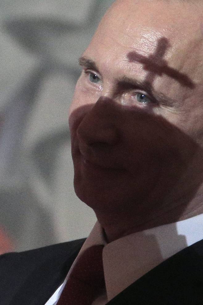 2015년 4월 12일 러시아 모스크바의 그리스도 구세주 대성당에서 열린 정교회 부활절 미사에 참석한 블라디미르 푸틴 러시아 대통령의 이마에 십자가 그림자가 드리우고 있다./EPA 연합뉴스