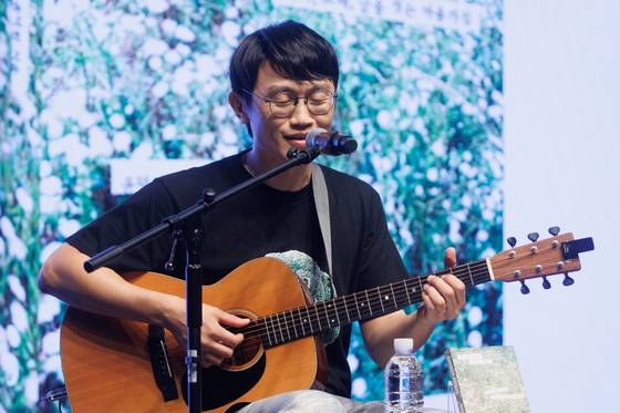 밴드 브로콜리너마저의 윤덕원이 2일 서울 종로구 노무현시민센터에서 열린 신간 '열심히 대충 쓰는 사람' 출간 기념 기자간담회에서 책 제목과 동명의 노래를 부르고 있다. 연합뉴스