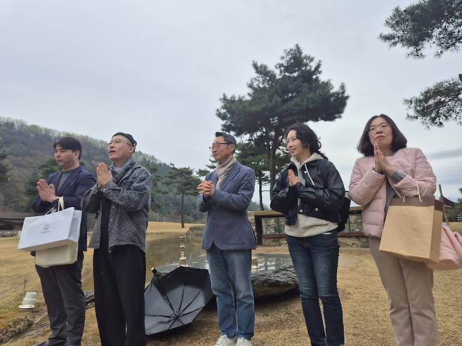 FAMS 2026 운영진인 이성현(맨왼쪽부터) 총괄, 한영용 전략자문, 이석구 위원장, 유명현 부위원장, 김소형 분과위원장이 불모 쪽을 바라보며 합장 인사를 올리고 있다.