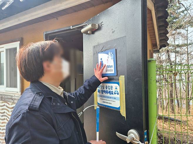 ▲ 지난달 27일 오후 인천 중구 월미공원에 있는 화장실 앞에서 시각장애인 A씨가 남자화장실 점자가 있는지 확인하고 있다. /안지섭 기자 ajs@incheonilbo.com