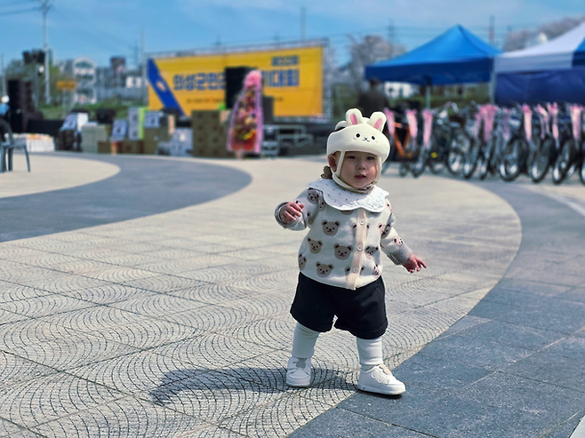 ▲ 12일 의성군 구봉공원 문소루 밑 음악분수 광장에서 열린 제32회 의성군민건강걷기대회에서 김다슬(16개월) 양이 토끼 모자를 쓴 채 광장 위를 걷고 있다. 뒤편에 놓인 경품 자전거와 무대가 이날 행사 분위기를 함께 보여준다. 김동현 기자 jhass80@kyongbuk.com