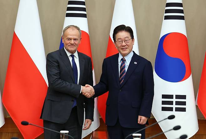 이재명 대통령과 도날트 투스크 폴란드 총리가 13일 청와대에서 확대 정상회담에 앞서 악수하고 있다.〈사진=연합뉴스〉