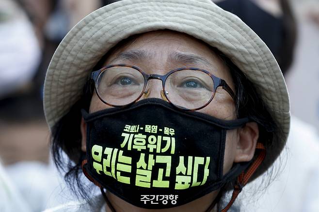 2022년 9월 24일 한 시민이 “기후위기 우리는 살고 싶다”는 글씨가 적힌 마스크를 쓰고 서울시청 일대에서 열린 집회에 참여하고 있다. 문재원 기자