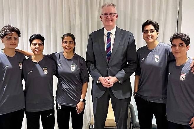 (FILES) An undated and unplaced photo released by Australia's Department of Home Affairs shows Iranian women's football team captain Zahra Ghanbari (2nd R) posing with Australian Home Affairs minister Tony Burke (3rd R) and other members of her team (L to 3rd L, and R) Fatemeh Pasandideh, Mona Hamoudi, Atefeh Ramezanizadeh, and Zahra Sarbali, who applied for asylum after competing in the Women's Asia Cup tournament being played in Australia. Iranian women's football team captain Zahra Ghanbari had withdrawn her Australia asylum bid, Iran state media said on March 15, 2026. (Photo by Handout / AUSTRALIAN DEPARTMENT OF HOME AFFAIRS / AFP) / ----EDITORS NOTE ----RESTRICTED TO EDITORIAL USE MANDATORY CREDIT " AFP PHOTO / DEPARTMENT OF HOME AFFAIRS" NO MARKETING NO ADVERTISING CAMPAIGNS - DISTRIBUTED AS A SERVICE TO CLIENTS
<저작권자(c) 연합뉴스, 무단 전재-재배포, AI 학습 및 활용 금지>