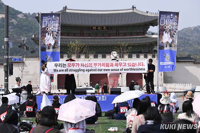 14일 서울 광화문광장에서 열린 ‘2026 광화문 멍때리기 대회’에서 기획자가 현수막으로 인사하고 있다.