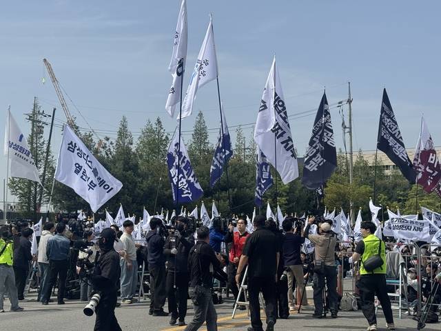 경기 평택 삼성전자 평택캠퍼스 앞에서 지난 23일 열린 투쟁 결의대회에서 삼성전자 노동조합 공동투쟁본부 관계자들이 깃발을 들고 있다.