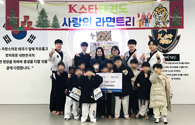 ▲K스타태권도가 아이들의 라면 1004개 기부를 기념해 단체 사진을 찍은 모습. /사진제공=태권도장