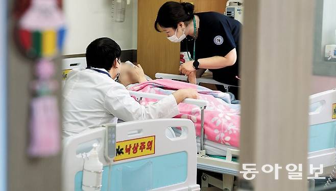 지난달 22일 충북 청주원광효도요양병원 내 호스피스 병동에서 고솔지 호스피스 팀장(오른쪽)과 김영탁 사회복지사(왼쪽)가 환자 김영미(가명·60대)씨에게 말을 걸고 있다. 김 씨처럼 연명의료 중단 후 호스피스를 제대로 받는 사람은 전체 연명의료 중단자의 30%뿐이다. 나머지 대다수가 호스피스를 제때 이용하지 못하고 숨지는 ‘임종 난민’이다. 청주=신원건 기자 laputa@donga.com