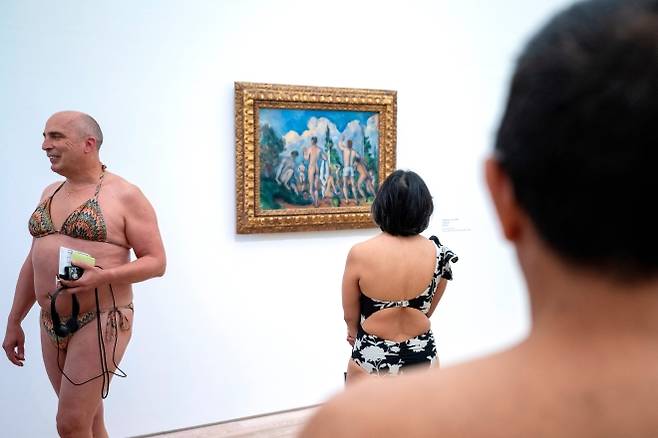 지난 1일(현지시간) 스위스 바젤 외곽 바이엘러 재단 미술관에서 열린 폴 세잔 전시회에서 수영복을 입은 관람객들이 ‘목욕하는 사람들’을 감상하고 있다. 2026.5.1 AP 연합뉴스