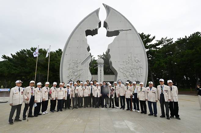 지난 2025년 장사상륙작전 전승기념공원을 배경으로 기념촬영을 하고 있는 장사상륙참전기념사업회 관계자 및 유격동지회원들 <장사상륙참전기념사업회 제공>